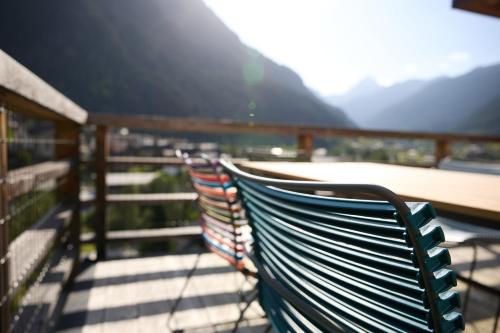 two benches sitting on a balcony with a view of mountains at DESIGN-CHALETS by Pferd auf Wolke NEU in Gaschurn