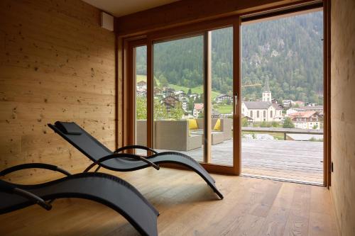 a chair in a room with a large window at DESIGN-CHALETS by Pferd auf Wolke NEU in Gaschurn