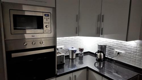 a kitchen with a stove and a microwave at Appartement agréable avec 2 très belles terrasses au coeur de Rabat in Rabat
