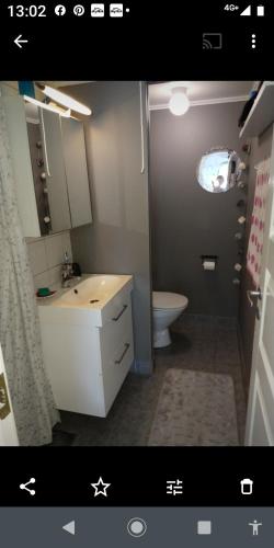 a bathroom with a white sink and a toilet at Nardo-Trondheim in Trondheim