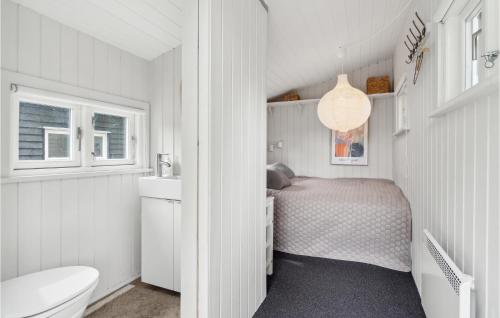 um pequeno quarto branco com uma cama e um WC em 3 Bedroom Nice Home In Sams em Sælvig