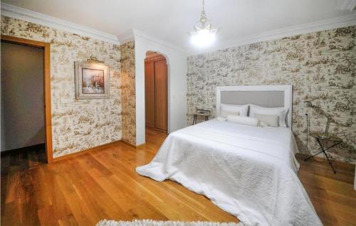 a bedroom with a white bed and a brick wall at 2 Bedroom Cozy Apartment In Carballo in Carballo