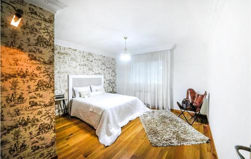 1 dormitorio con cama blanca y suelo de madera en Stunning Apartment In Carballo With 2 Bedrooms, en Carballo