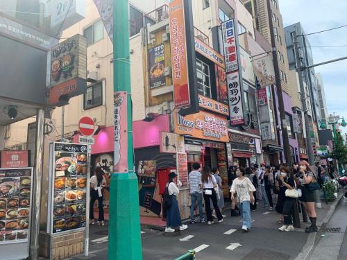 um grupo de pessoas andando por uma rua movimentada da cidade em City Hotel Dolphin em Tóquio