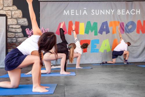 a group of people doing yoga on mats at Melia Sunny Beach All Inclusive in Sunny Beach
