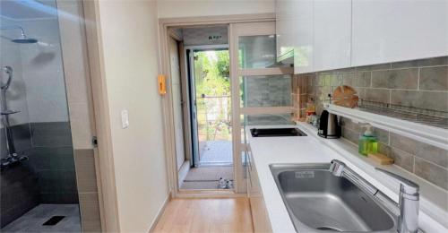 a kitchen with a sink and a shower at Living in Jeju Island in Jeju