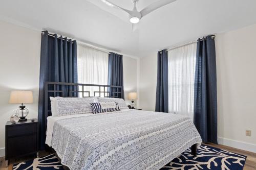a bedroom with a large bed with blue curtains at A Time to Lime in Galveston