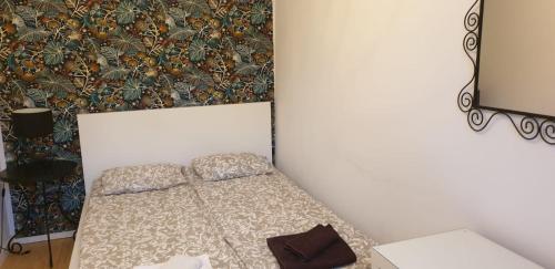 małe łóżko w pokoju ze ścianą w obiekcie Apartament Turkusowy w Szczecinie