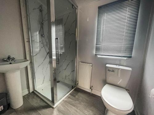 a bathroom with a shower and a toilet and a sink at 6 Berth Caravan With Wifi At Steeple Bay Holiday Park In Essex Ref 36092f in Southminster