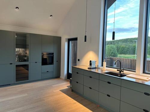 uma cozinha com um lavatório e uma grande janela em Villa Nordheim em Tromsø