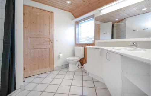 y baño con aseo, lavabo y espejo. en Amazing Home In Blvand With 5 Bedrooms, Sauna And Indoor Swimming Pool en Blåvand