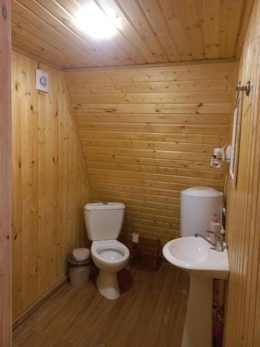 ein Holzbadezimmer mit einem WC und einem Waschbecken in der Unterkunft GREEN AREA in Batumi