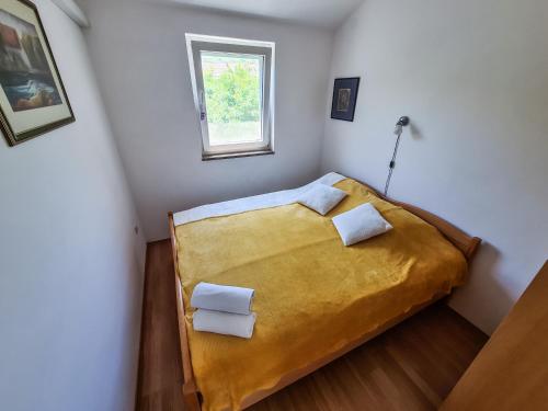 una piccola camera da letto con un letto con due cuscini di Apartment Hrastov a Soline