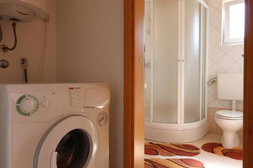 bagno con lavatrice e servizi igienici di Apartment Hrastov a Soline