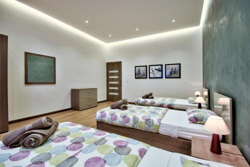 ein Schlafzimmer mit 2 Betten und einem Tisch mit Lampen in der Unterkunft Villa Ghea - Indoor Jacuzzi Pool, Sauna and Games Room in Mellieħa