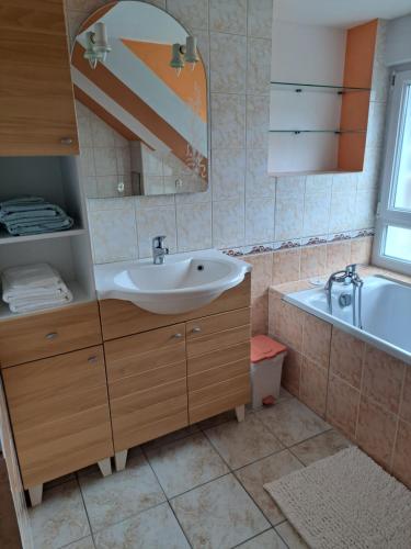 W łazience znajduje się umywalka, wanna i lustro. w obiekcie Maison 2 chambres - canal - vilaine w mieście Saint-Nicolas-de-Redon