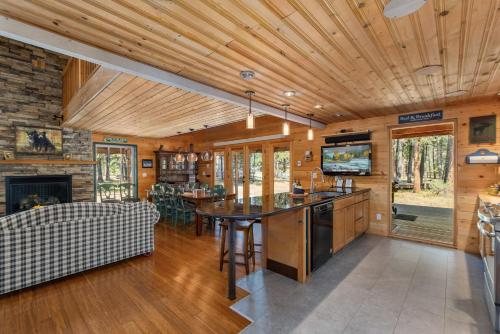 cocina y sala de estar con mesa y TV en Pine Acres by NW Comfy Cabins, en Leavenworth
