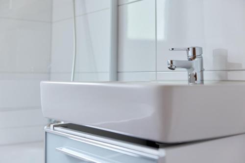 a white sink in a bathroom with a mirror at Alpenhaus Montafon by Pferd auf Wolke in Gargellen