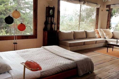 een slaapkamer met een bed, een bank en ramen bij Casa Tomine in Guatavita