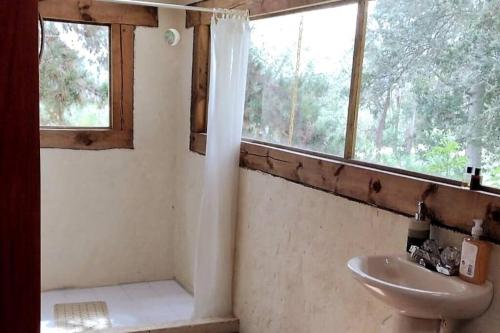 een badkamer met een wastafel en een toilet en een raam bij Casa Tomine in Guatavita