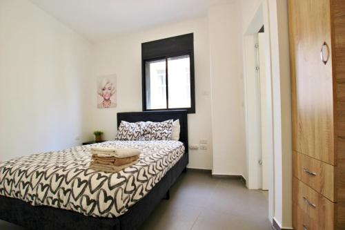 1 dormitorio con cama y ventana en beautiful 2 bedrooms apartment with balcony, en Tel Aviv