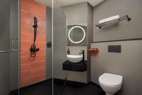 a bathroom with a toilet and a sink and a shower at Ginger Noida 63 in Noida