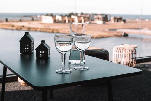 dos vasos de agua sobre una mesa con vistas en Matruusi - upea yksiö merinäköalalla, en Kalajoki