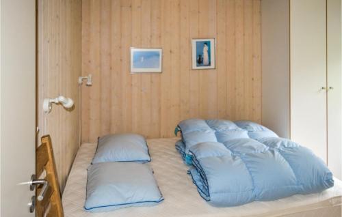 a row of pillows sitting on a bed in a room at Stunning Home In Sby With 3 Bedrooms, Sauna And Wifi in Nordost