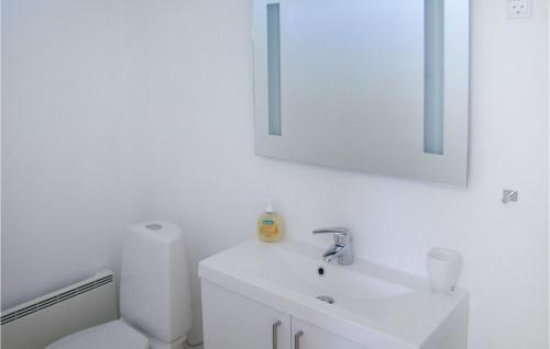 Baño blanco con lavabo y espejo en Lovely Home In Strandby With Wifi, en Strandby