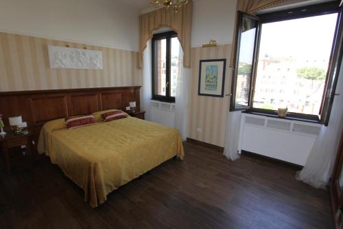 a bedroom with a bed and two windows at Area Sacra Relais in Rome