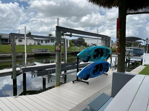 two kayaks sitting on a dock next to a marina at Heated pool, Family Fun, Tiki Bar, kayak, 3bd 2ba in Cape Coral