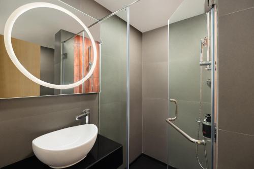 ein Badezimmer mit einem weißen WC und einem Spiegel in der Unterkunft Ginger Vadodara in Vadodara