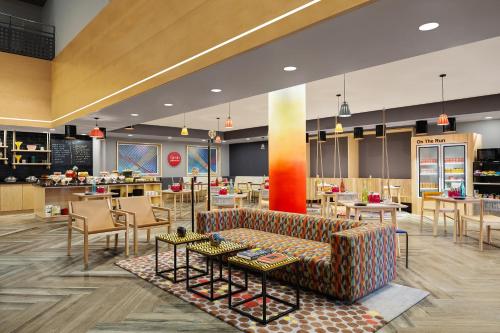 a lobby with a couch and tables and chairs at Ginger Vadodara in Vadodara