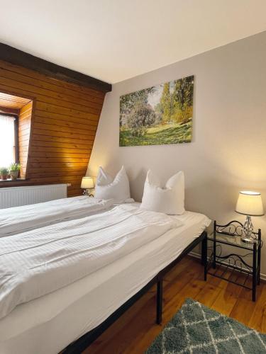 a bedroom with a large white bed in a room at Ferienhaus Schuhhof in Quedlinburg