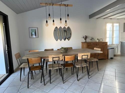 - une cuisine avec une table et des chaises en bois dans l'établissement Grande maison proche de la plage, à La Couarde-sur-Mer