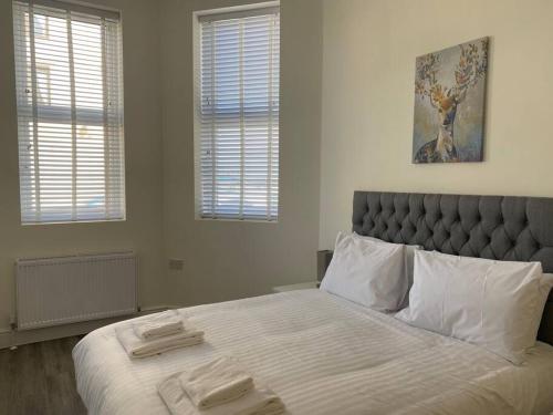 a bedroom with a large bed with two towels on it at Space Apartments - Two Bed Seafront Apartment with Off Street Parking - Windfarmer Accommodation - Flat 1 in Harwich