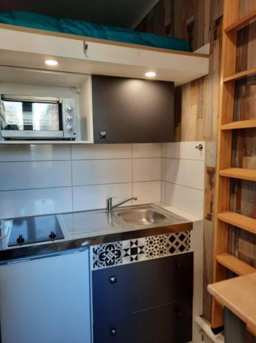une petite cuisine avec un évier et un micro-ondes dans l'établissement PIED A TERRE STRATEGIQUE, à Marseille