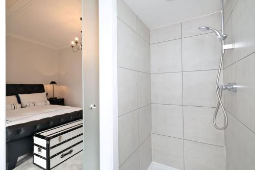 a white bathroom with a shower and a bed at Luxury West End Apartment in Aberdeen