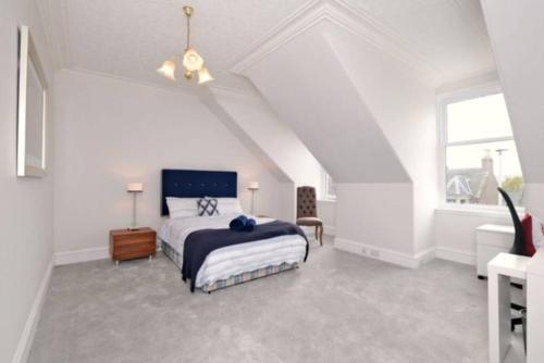 a white bedroom with a bed and a window at Luxury West End Apartment in Aberdeen