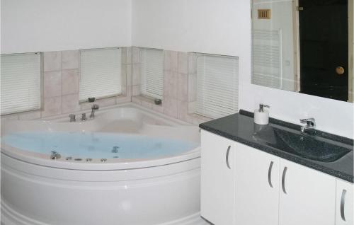 uma casa de banho branca com uma banheira e um lavatório em Amazing Home In lbk With Wifi em Ålbæk