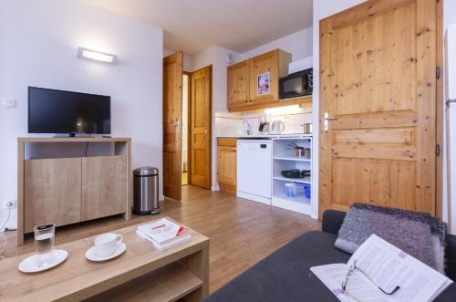 a living room with a couch and a table at Résidence Odalys Le Buet in Morillon
