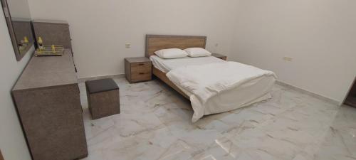 a bedroom with a bed and a tiled floor at شقة ثلاث غرف نوم بريدة حي الحمر in Buraydah