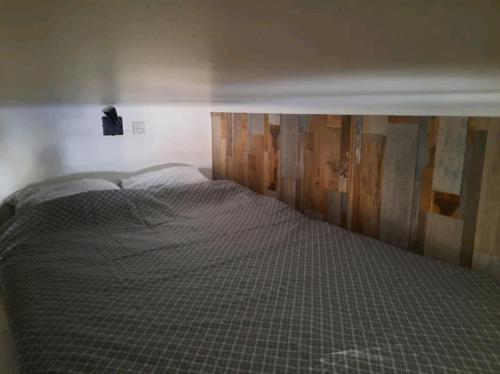 un lit avec une tête de lit en bois dans une chambre dans l'établissement PIED A TERRE STRATEGIQUE, à Marseille
