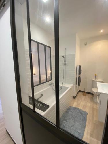 a bathroom with a tub and a toilet and a sink at Chambre & salle de bain privée - LV 33 in Argenton-sur-Creuse