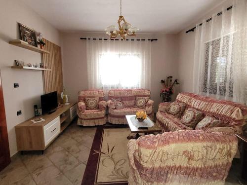 ein Wohnzimmer mit 2 Sofas und einem TV in der Unterkunft Casa Shtoj I Vjeter, Shkoder 