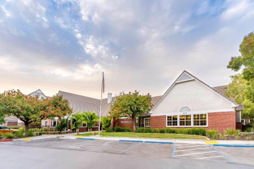 a building with an american flag in a parking lot at Residence Inn Sacramento Rancho Cordova in Rancho Cordova