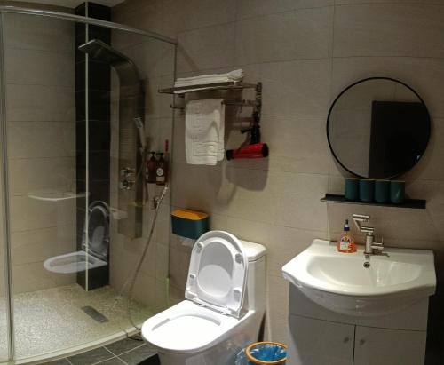 a bathroom with a shower and a toilet and a sink at Kanalung Yurakucho House in Taimali