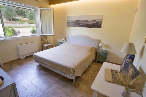 a bedroom with a bed and a table and a window at Agrestia azienda agricola in Bertinoro