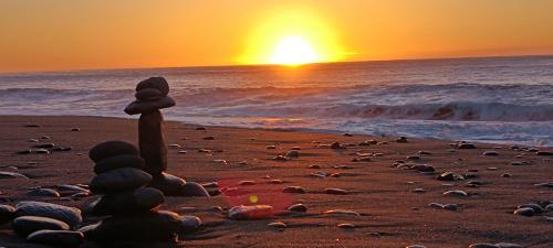 a stack of stones on a beach at sunset at Kanalung Yurakucho House in Taimali