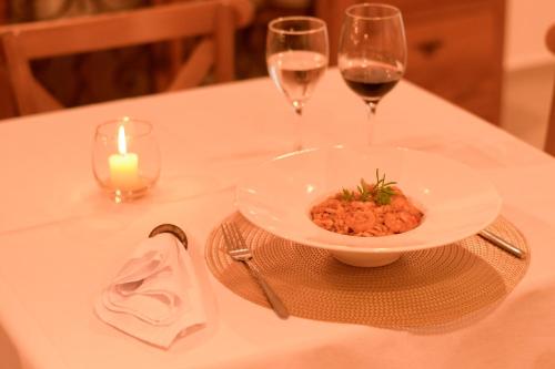 a table with a bowl of food and two glasses of wine at Milie Lounge Pousada in Japaratinga
